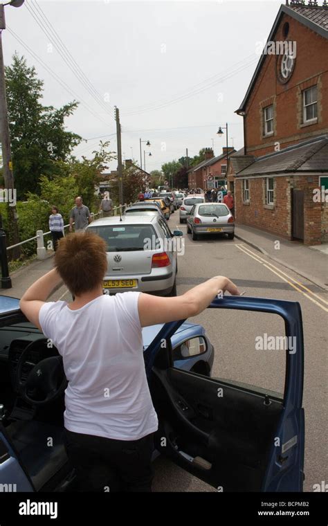 Woman Stuck In Traffic Jam Has Got Out Of Her Car To Watch Stock Photo