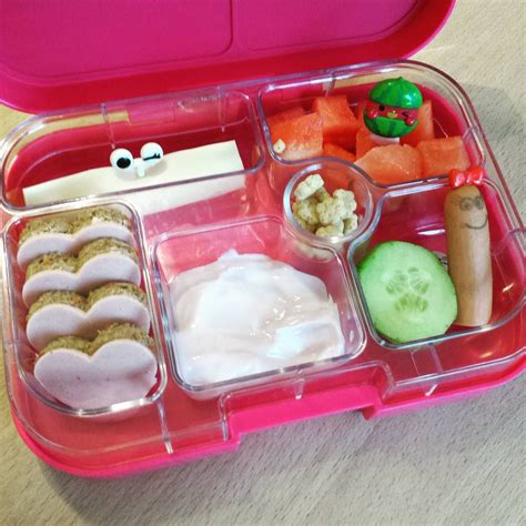 A Pink Lunch Box With Food In It