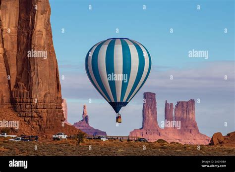 A Hot Air Balloon Flying In Front Of The Utah Monuments In The Monument