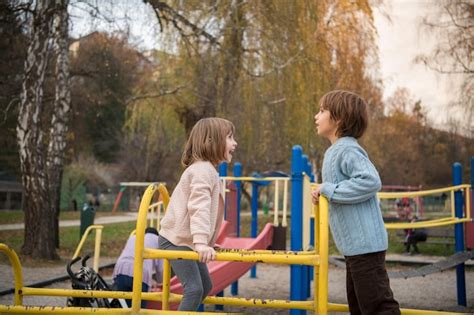 Cutte petite fille et garçon dans un parc pour enfants s amusant et s