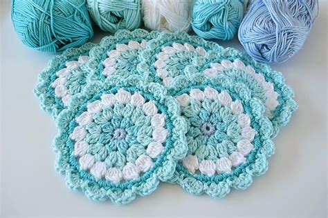 Crocheted Balls Of Yarn Sitting Next To Each Other On A White Table Top