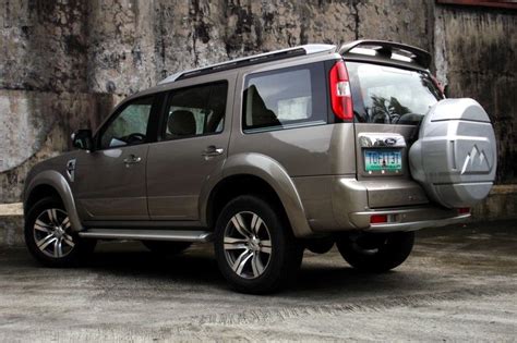 A Silver Suv Parked In Front Of A Stone Wall