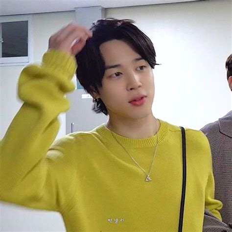 A Man In A Yellow Sweater Is Holding His Hair