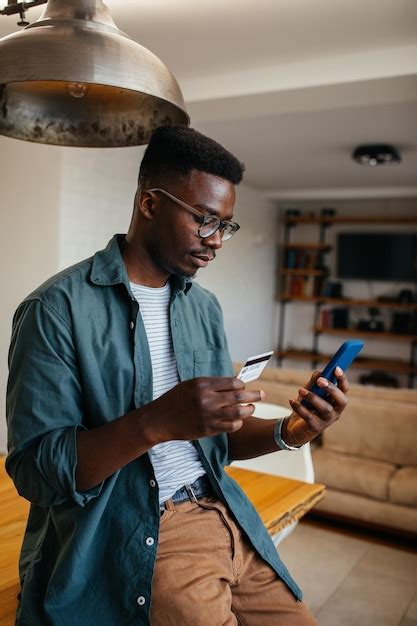 Hombre negro comprando en línea a través de un teléfono celular Foto