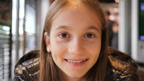 Happy kid girl portrait smile face as she sit in fast food restaurant ...