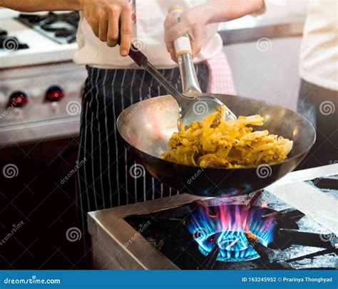 Chef Cocinando Con Llama En Una Sartén Frita En Una Cocina Foto de