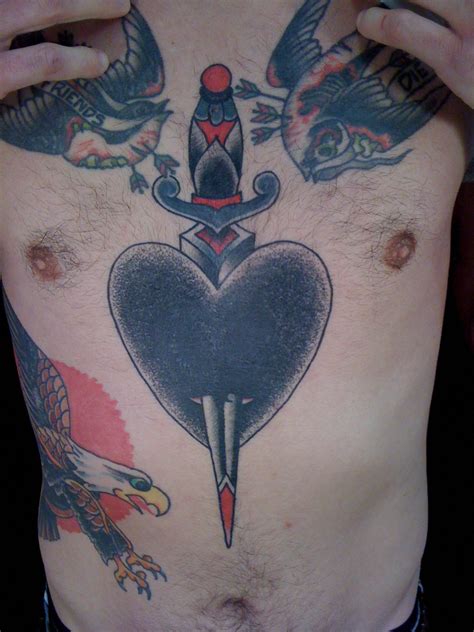 Jeb Maykut - Flyrite Tattoo: Black heart with dagger chest tattoo