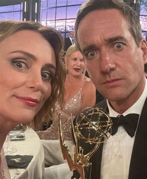 A Man And Woman Pose With An Award In Front Of Them At A Formal Event