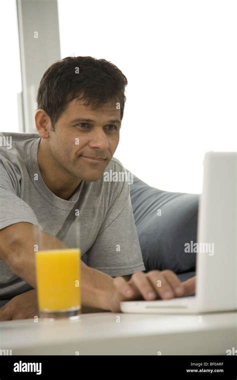 Mature Man Sitting On A Couch And Using A Laptop Stock Photo Alamy