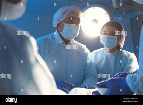 Team Of Professional Doctors Performing Operation In Surgery Room Stock