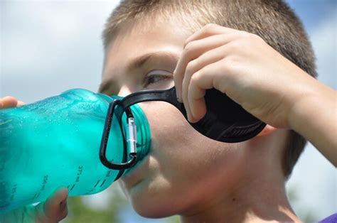 Premium Photo | A boy drinking a water bottle