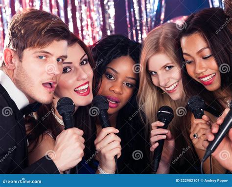 Friends Singing Into Microphones At Karaoke Party Stock Image Image