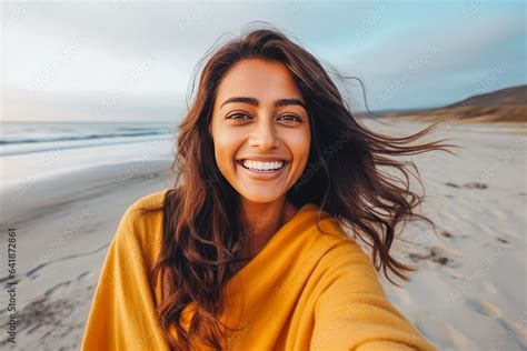 Beautiful Young Indian Woman Enjoying A Day On The Beach While Smiling And Making A Picture