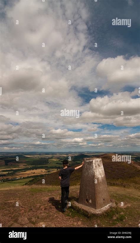 Boy Standing By Trig Point On The Middle Eildon Melrose Stock Photo