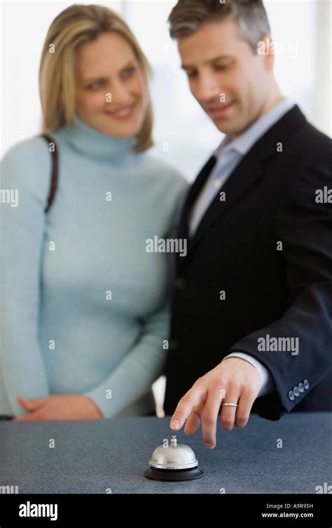 Couple ringing bell at counter Stock Photo - Alamy