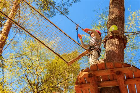 enjoying activity in climbing adventure park. summer day. Rope park ...