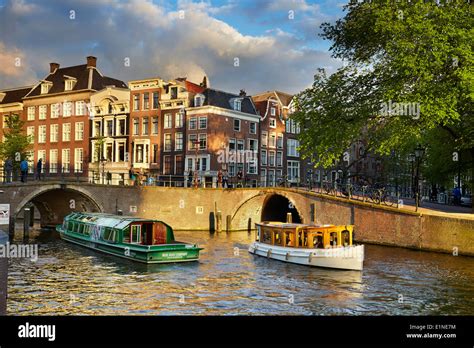 Tourist boat at Amsterdam bridge canal - Holland, Netherlands Stock ...