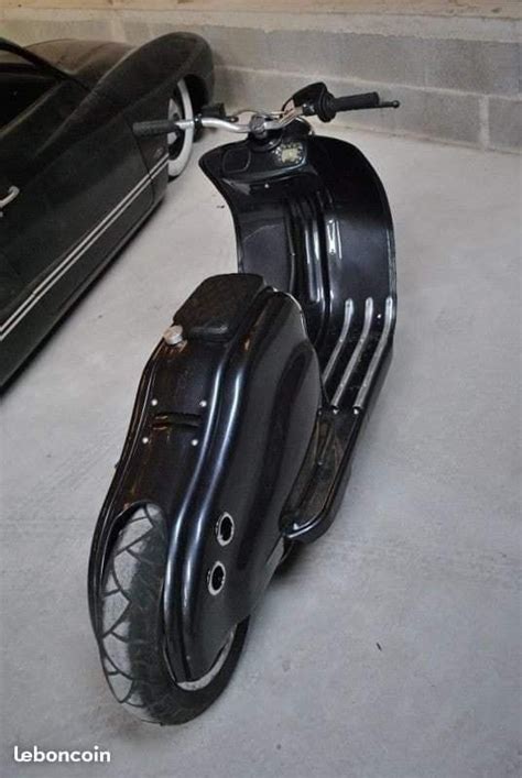 A Black Scooter Parked Next To A Car