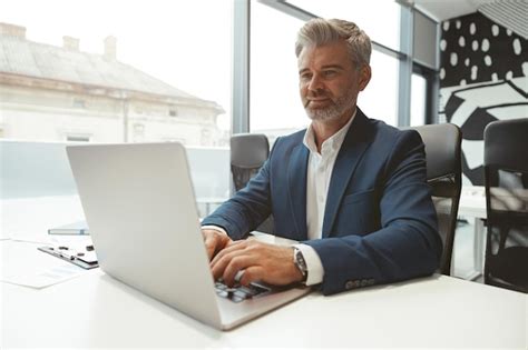 Premium Photo Busy Mature Businessman Working With Laptop While