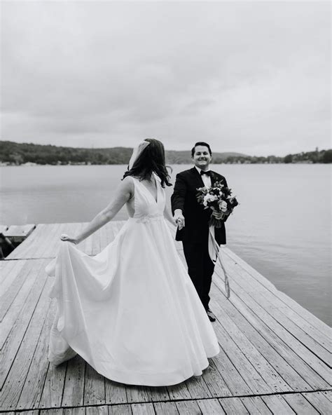 A Bride And Groom Are Walking On The Dock