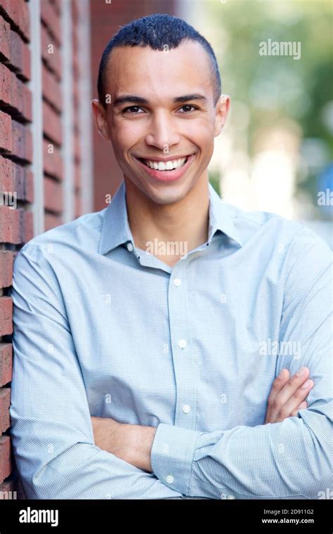 Portrait Of Smiling North African Businessman Leaning On Wall Outdoors