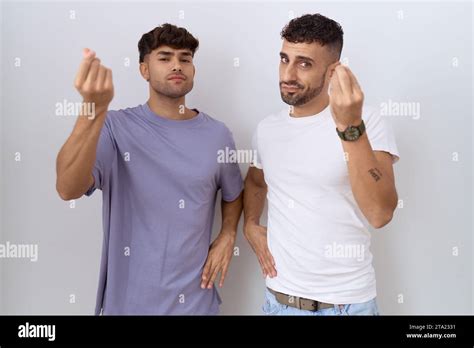 Homosexual Gay Couple Standing Over White Background Doing Italian Gesture With Hand And Fingers