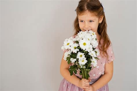 Vue De Face De La Petite Fille Tenant Le Bouquet De Fleurs De Printemps