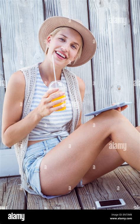 Pretty Blonde Woman Using Her Tablet And Holding Orange Juice Stock Photo Alamy