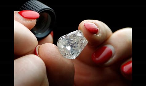 A 30-carat rough diamond is viewed at the offices of a polishing ...