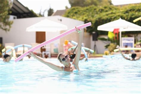 Premium Photo Woman In Sunglasses Standing In Pool And Holding Noodle