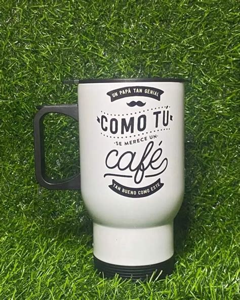 A White Coffee Mug Sitting On Top Of Green Grass With The Words Como Tu