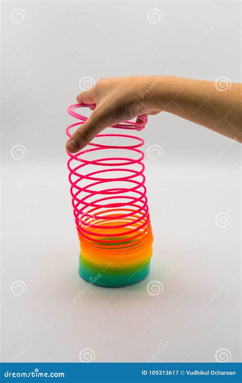 Hand Holding Rainbow Slinky Spring Toy Isolated On White Editorial Photography Image Of Pink