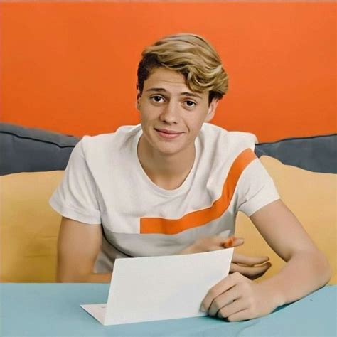 A Young Man Sitting At A Table With A Piece Of Paper In Front Of Him