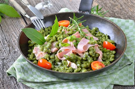 Südtiroler Spinatspätzle mit Parmesansoße und Schinken foto de Stock