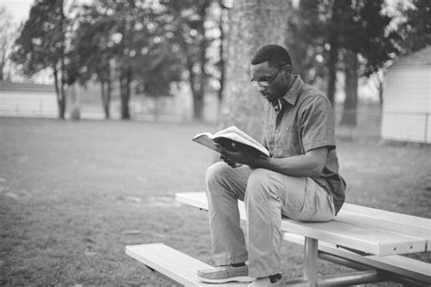 Man Reading Bible On Picnic Table