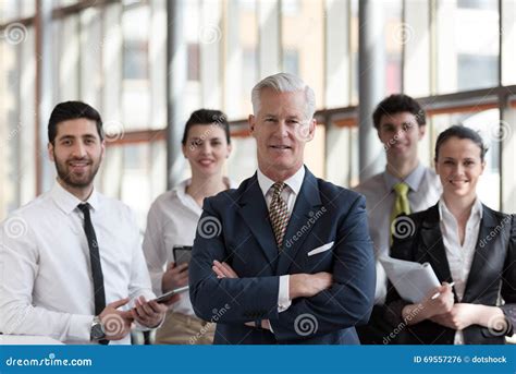 Portrait Of Senior Businessman As Leader With Group Of People I Stock