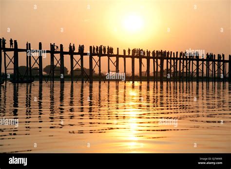 Sunset Silhouettes Of People Walking Over The U Bein Teak Bridge In