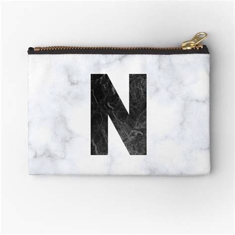 The Letter N Is Made Up Of Black And White Marble With Gold Zippered