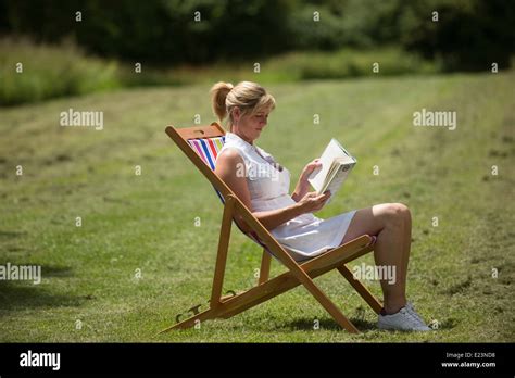 Femme Assise Dans Un Livre De Lecture De Chaise Longue Banque De