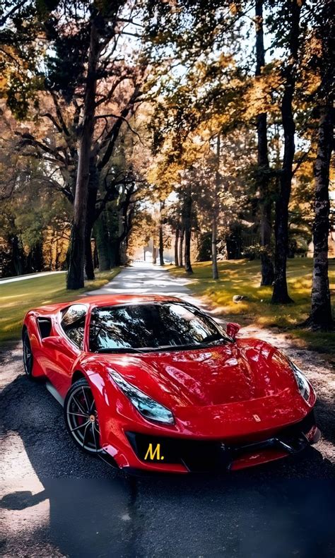 A Red Sports Car Parked On The Side Of A Road In Front Of Some Trees