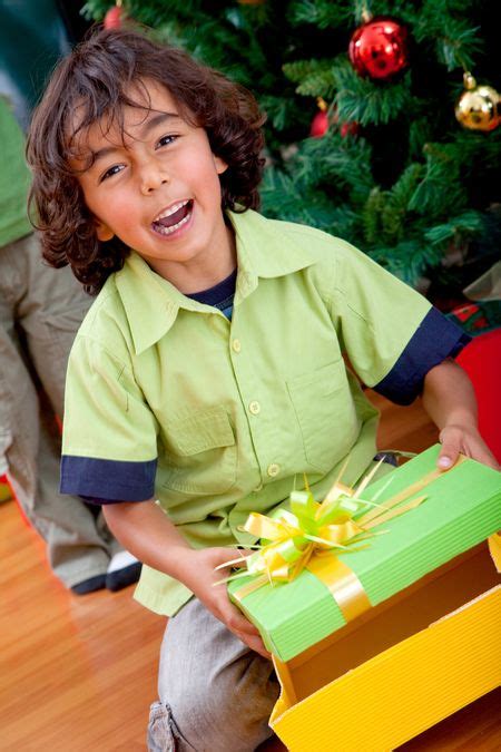 Happy kid opening a Christmas gift and smiling | Freestock photos