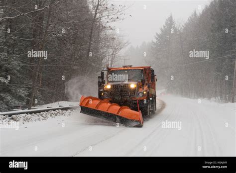 A snow plow clears the road as it snows in Vermont Stock Photo - Alamy