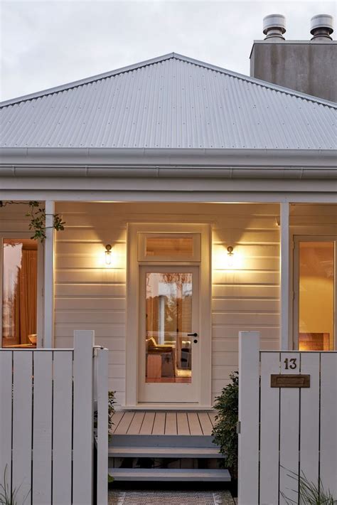 A White House With A Porch And Steps Leading To The Front Door