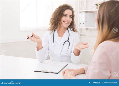 Female Doctor Giving Consultation To Patient At Clinic Stock Image