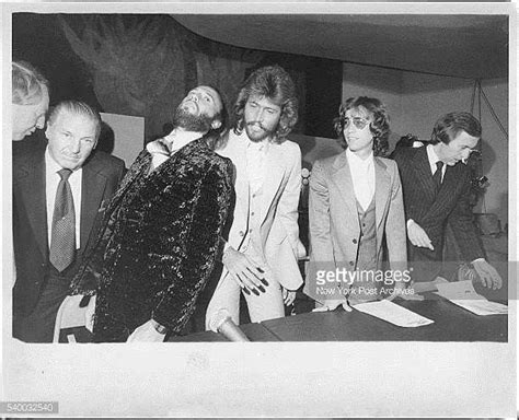 Men In Suits And Ties Standing Around A Table With Papers On It