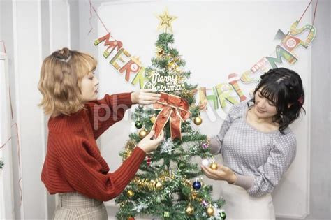 クリスマスツリーの飾りつけをする2人の女性 No 22799784｜写真素材なら「写真ac」無料（フリー）ダウンロードok