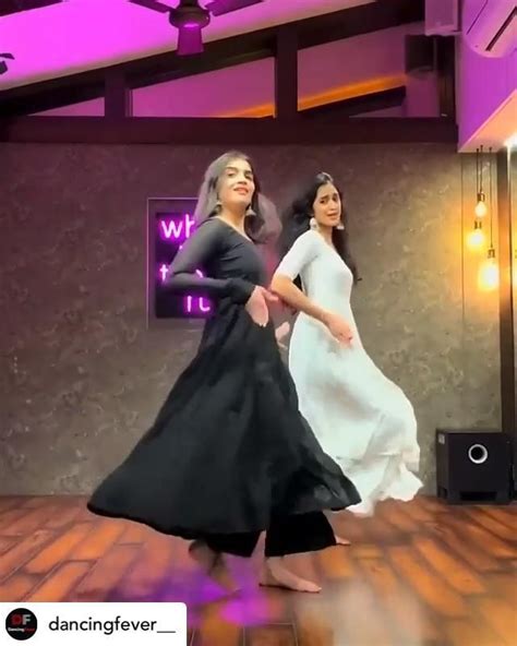 Two Women In Long Dresses Are Dancing On A Wooden Floor With Purple