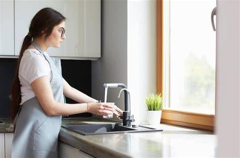 Mano De Mujer Llenando El Vaso De Agua Foto Premium