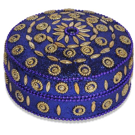 a blue box with gold designs on the lid and bottom, sitting on a white ...