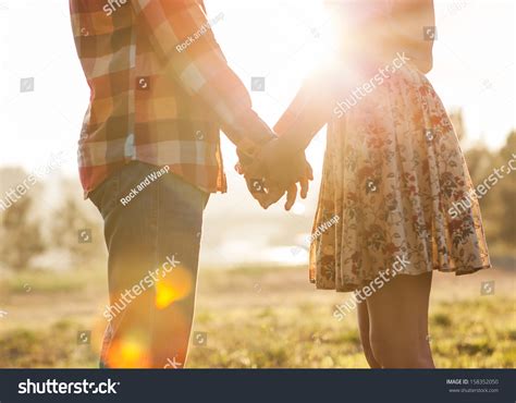 Young Couple In Love Walking In The Autumn Park Holding Hands Looking